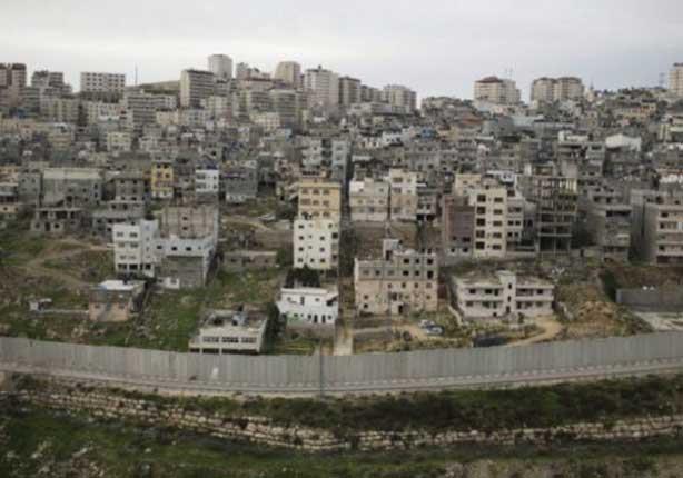 يفصل الجدار العازل بين المناطق الفلسطينية والإسرائ