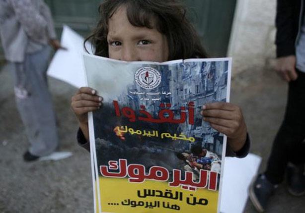 طفلة فلسطينية ترفع مصلقا للتضامن مع العالقين في مخ