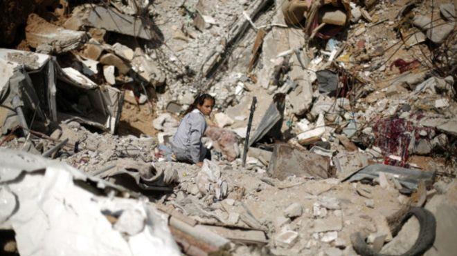 فتاة فلسطينية تجلس وسط حطام منزلها الذي دمر في الع