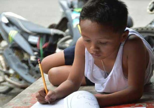 صبي فيليبيني يدرس على الرصيف ويتلقى تبرعات كبيرة