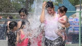 الأطفال يستخدمون المياه للتخفيف من الحرارة الشديدة
