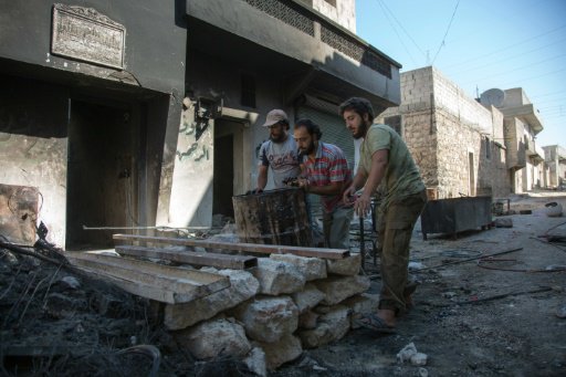 سوريون يعملون على احراق برميل مليء بالبلاستيك بغية