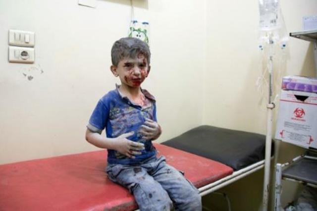 طفل سوري مصاب ينتظر تلقي العلاج في مستشفى ميداني ف