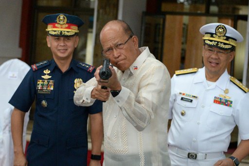 وزير الدفاع الفيليبيني دلفين لورينزانو يجرب بندقية