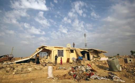 اسرة عراقية امام ركام منزلها في برزان في محافظة ني