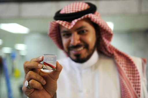 مسافر يحمل هدية صغيرة من الخطوط الجوية السعودية في