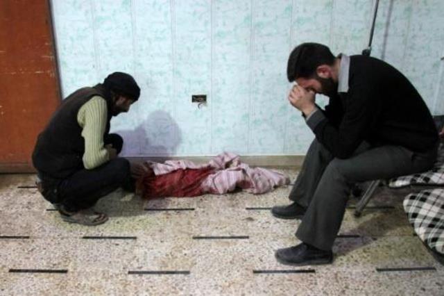 سوريون يبكون طفلا قتل في القصف على مدينة دوما في 1