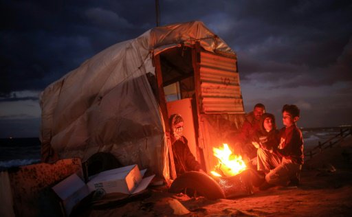 أطفال فلسطينيون أشعلوا نارا للتدفئة قرب الشاطىء في