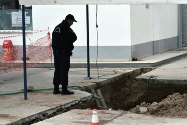 شرطي يتفقد الحفرة حيث عُثر على القنبلة في سالونيكي