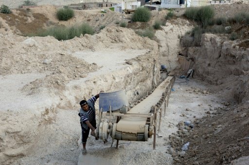 عامل فلسطيني يتفحص آلة على مدخل انفاق تهريب على حد