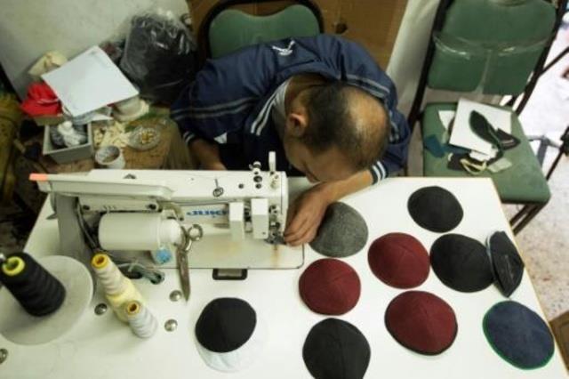 عامل فلسطيني في مصنع للقلنسوات في غزة