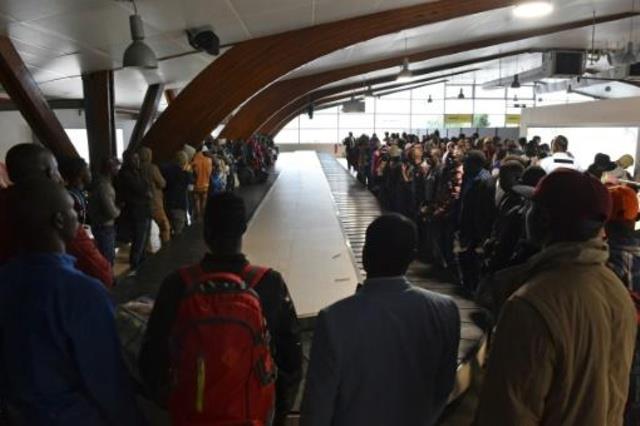 مواطنون من ساحل العاج ينتظرون وصول حقائبهم في مطار