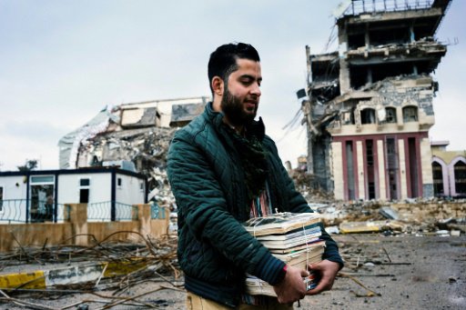 طالب الصيدلة عبد الستار الحمداني يحمل كتبه امام مب
