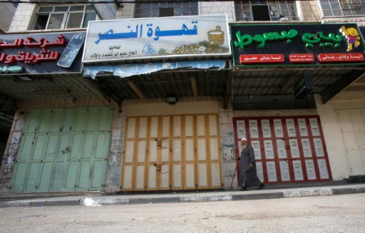 فلسطيني يمر امام محال مقفلة في الخليل تضامنا مع ال