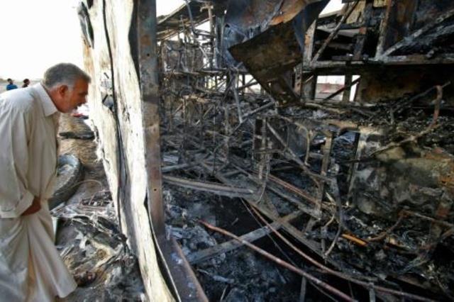 عراقي يتفقد الدمار الذي لحق بحافلة بعد انفجار سيار