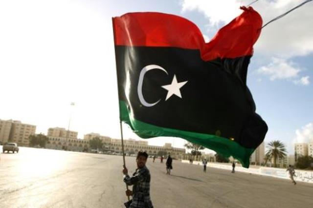 ليبي يرفع العلم في بنغازي في 27 فبراير 2015 (أ ف ب