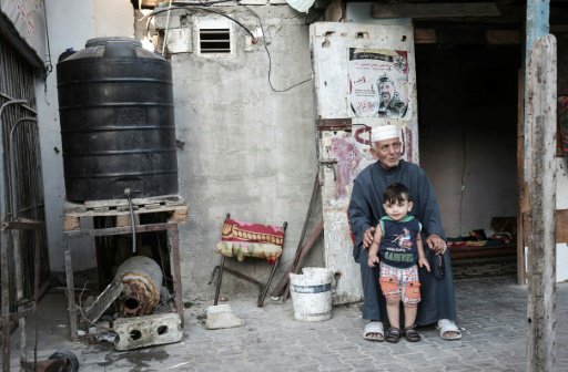 رجل فلسطيني مع طفل في مخيم رفح للاجئين في جنوب قطا