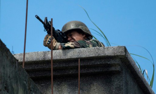 جندي فيلبيني يصوب سلاحه نحو مواقع المسلحين الإسلام