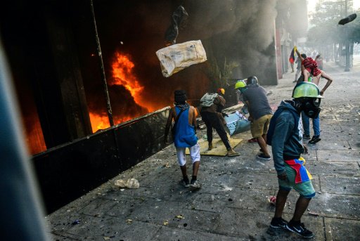 متظاهرون من المعارضة الفنزويلية يضرمون النار في مب