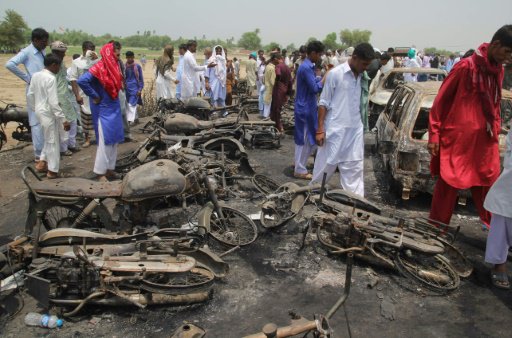 باكستانيون يتفقدون موقع احتراق الصهريج، في 26 حزير