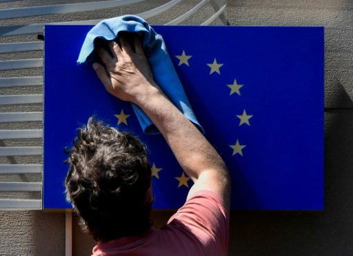 عامل ينظف شعار الاتحاد الاوروبي امام ممثلية التكتل