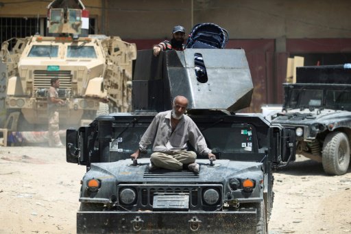 نازح عراقي يجلس على متن مدرعة تابعة للقوات العراقي