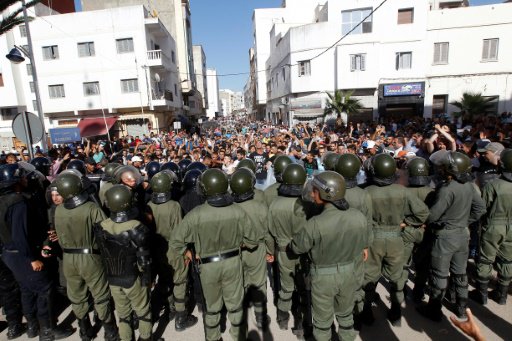 متظاهرون يهتفون أمام قوات الأمن المغربية خلال مسير