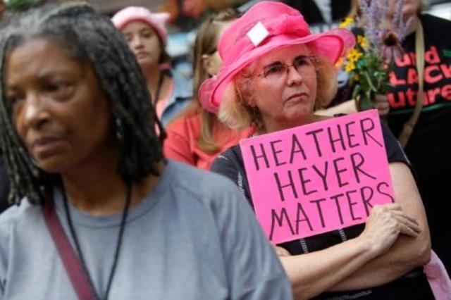 امرأة تحمل لافتة عليها اسم هيذر هيير خلال تجمع تكر