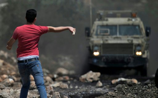 متظاهر فلسطيني يرشق قوات الامن الاسرائيلية بالحجار