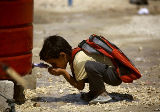 طفل سوري نازح من الرقة يشرب المياه في مخيم للنازحي