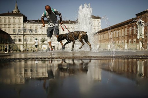  رجل ينعش نفسه وكلبه بالمياه في نافورة في بيازا كا