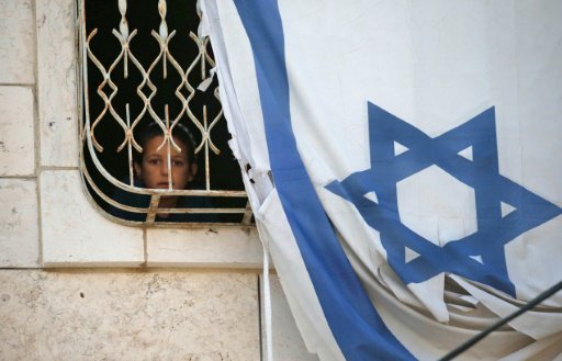 طفل ينظر عبر نافذة بيت فلسطيني يحتله مستوطنون في م