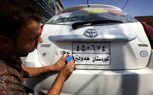 عراقي كردي يضع ملصقا على لوحة سيارة كتب عليه بالكر