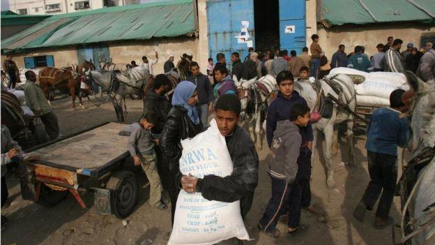 الفلسطينيون أثناء حصولهم على المساعدات الغذائية من