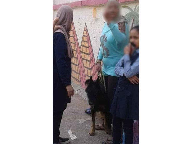 السيدة بجانب الطالبة وفي يدها كلب الحراسة