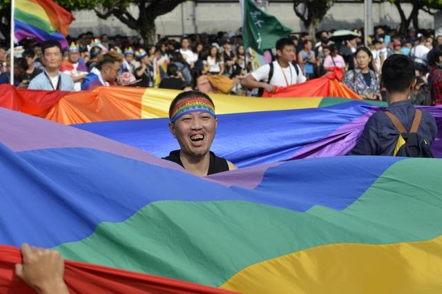 أحد النشطاء في تايوان يحمل علم قوس قزح أثناء تظاهر