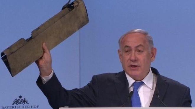 نتنياهو يمسك بيده قطعة من حطام طائرة بدون طيار يقو