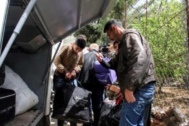 لاجئون سوريون يوضبون حقائبهم مع استعدادهم لمغادرة