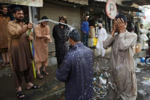 عمال باكستانيون يرشون انفسهم بالماء وسط موجة الحر 