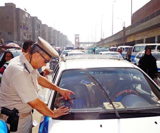 مدير المرور يضع الملصقات علي السيارات