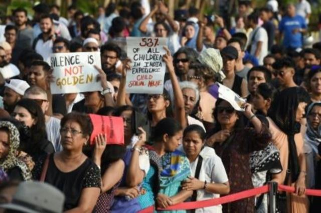 متظاهرون يرفعون لافتات تدعم ضحايا الاغتصاب