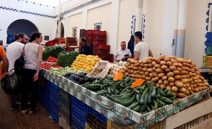 أشخاص يشترون خضروات في سوق بتونس العاصمة