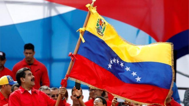 مادورو يحمل علم فنزويلا