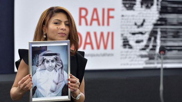 إنصاف حيدر تحمل صورة زوجها المسجون رائف البدوي