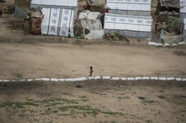 طفلة تلعب بمفردها عند حدود أحد مخيمات النازحين