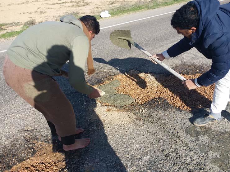 شباب من مطروح يبادرون لإصلاح الطريق الدولي