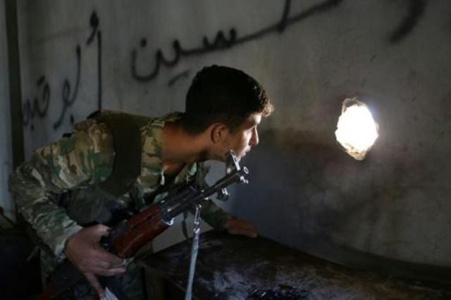مقاتل سوري من القوات المدعومة من أنقرة ينظر من ثقب