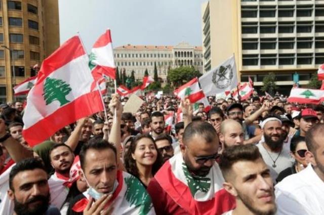 متظاهرون يحملون العلم اللبناني في وسط بيروت