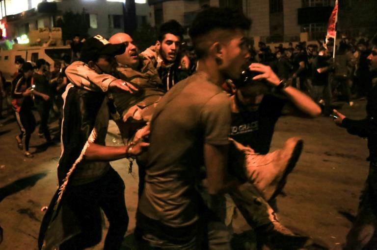 متظاهرون يحملون جنديًا عراقيًا خلال الاحتجاجات الم