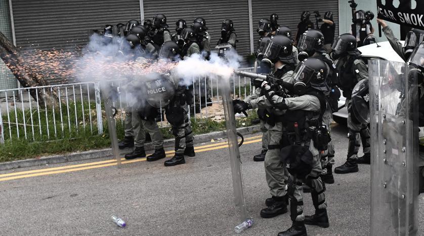 شرطي يطلق الغاز المسيل للدموع على المتظاهرين في هو